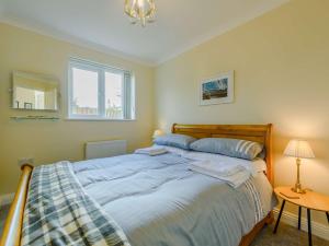 a bedroom with a bed with blue sheets and a window at 4 Bed in Braunton 89603 in Braunton