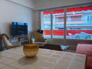 a living room with a table and a large window at 100m des plages centre Antibes in Antibes