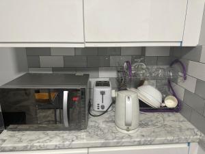 a kitchen counter top with a toaster and a microwave at Feel at home in Abbey Wood