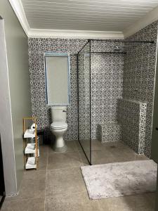 a bathroom with a toilet and a glass shower at Florie se Huis in Paarl