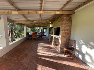 a patio with a fireplace and a table and chairs at Florie se Huis in Paarl