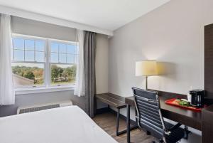 a hotel room with a bed and a desk and a window at Saco Bay Hotel in Saco +10 photos