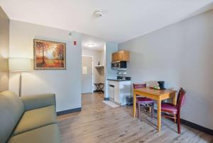 a living room with a table and a kitchen at Saco Bay Hotel in Saco