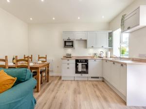 a kitchen and dining room with white cabinets and a table at The Barrels at Leintwardine in Leintwardine