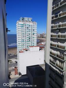 una ventana con vistas a un edificio blanco alto en 2 amb Maral 48 Mar del Plata en Mar del Plata