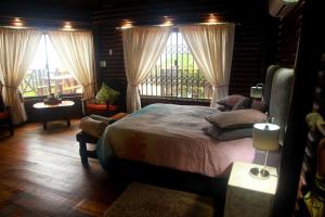 una camera con un grande letto e una finestra di Mzimayi River Lodge a Hibberdene