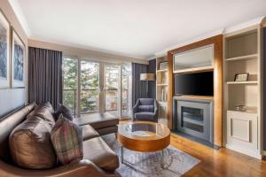 ein Wohnzimmer mit einem Ledersofa und einem TV in der Unterkunft Hilton Grand Vacations Club Craigendarroch Suites Scotland in Ballater