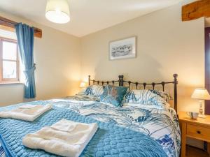 - une chambre avec un lit bleu et 2 serviettes dans l'établissement 1 Bed in Barmouth 89777, à Dyffryn