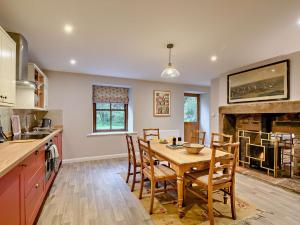 a kitchen with a table and chairs and a fireplace at 3 Bed in Lockerbie 89759 in Ecclefechan