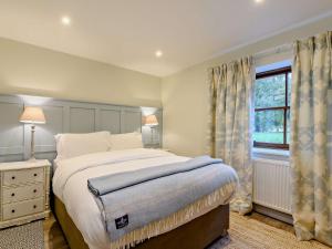 a bedroom with a large bed and a window at 3 Bed in Lockerbie 89759 in Ecclefechan