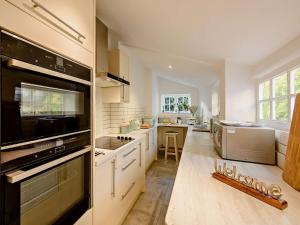 a large kitchen with white cabinets and a large window at 2 Bed in Arundel 89671 in Arundel