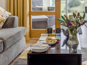 a living room with a table with a vase of flowers at 1 Bed in Polyphant 89860 in Trewen