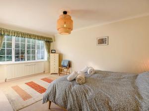 a bedroom with a bed and a window and a chair at 4 Bed in Bridport 89788 in Corscombe