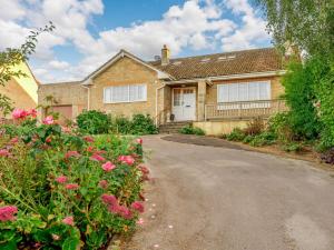 una casa de ladrillo con entrada y flores rosas en 4 Bed in Bridport 89788, en Corscombe