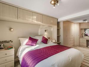 ein Schlafzimmer mit einem großen weißen Bett mit rosa Kissen in der Unterkunft 2 Bed in Pateley Bridge 89622 in Summer Bridge