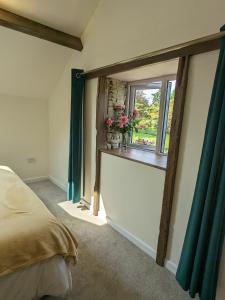 a bedroom with a bed and a window with flowers at The Barrels at Leintwardine in Leintwardine