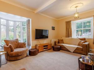 4 Bed in Pitlochry 89750 في Tummel Bridge: غرفة معيشة مع أريكة وتلفزيون