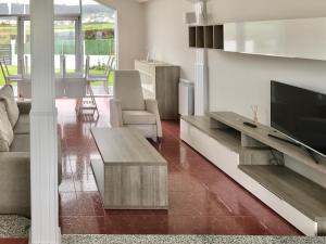 a living room with a tv and a couch and a table at Apartagal- Casa Playa, Foz in Foz
