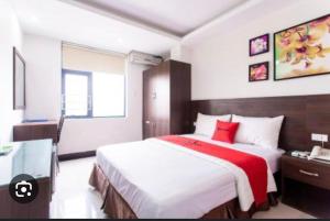 a bedroom with a large bed with a red blanket at Rita Hotel Home- Airport Tân Sơn Nhất- Cạnh Bệnh Viện Tâm Anh & Gần Quân Khu 7 in Ho Chi Minh City