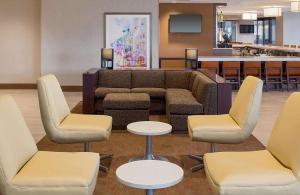 a waiting room with a couch and two tables and chairs at Hyatt House New Orleans Downtown in New Orleans