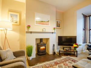 a living room with a fireplace and a tv at 3 Bed in Llanfairfechan 89646 in Llanfairfechan