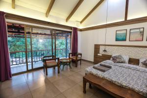- une chambre avec un lit, une table et des chaises dans l'établissement The Preserve Stone House Bungalow, à Meppādi