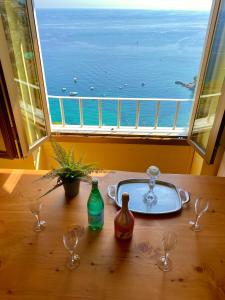 a table with glasses and a bath tub in front of a window at Kiss of sea - Balzi Rossi & Baia Beniamin in Ventimiglia