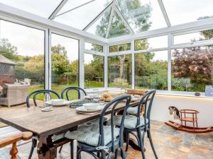a conservatory dining room with a wooden table and chairs at 3 Bed in Alfriston 89657 in Alfriston