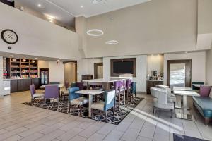 a restaurant with tables and chairs and a tv at La Quinta by Wyndham North Orem in Orem