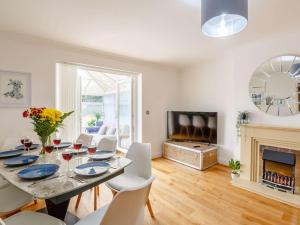 a dining room with a table and chairs and a fireplace at 4 Bed in Llandudno 89703 in Deganwy