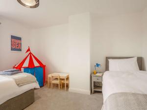 una camera con 2 letti e un tavolo con una tenda di 4 Bed in Llandudno 89703 a Deganwy