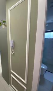 a door in a bathroom with a toilet at Flat Homebusiness ao centro! in Pomerode