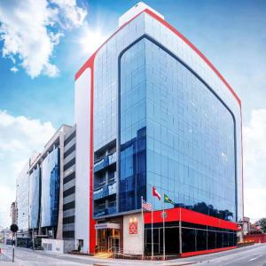 un grand bâtiment en verre avec une bande rouge. dans l'établissement Hilton Garden Inn Lima Surco, à Lima