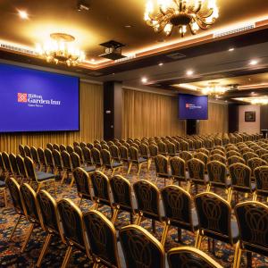 uma sala de conferências com cadeiras e um ecrã de projecção em Hilton Garden Inn Lima Surco em Lima