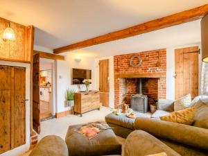 a living room with a couch and a fireplace at 3 Bed in Pulham St Mary 89618 in Pulham