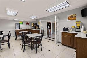 a restaurant with tables and chairs and a kitchen at Quality Inn & Suites Vidalia in Vidalia