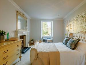 a bedroom with a bed with a dresser and a fireplace at 2 Bed in Cairngorms 89717 in Inverurie
