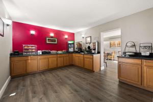 a hair salon with a red wall and wooden cabinets at Econo Lodge in Richmond