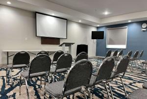 a conference room with chairs and a screen at Comfort Suites Oil Center in Lafayette +21 photos