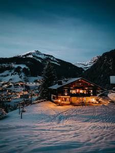 un rifugio da sci nella neve di notte di Mountain Chalet Pra Ronch a Selva di Val Gardena