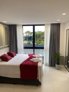 a bedroom with a large bed and a large window at Flat 205 Homebusiness perto do centro! in Pomerode +44 photos
