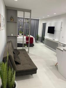 uma sala de estar com um sofá e uma cama em Flat Homebusiness ao centro! em Pomerode