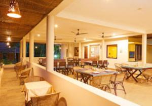 - une salle à manger avec des tables, des chaises et un porte-table dans l'établissement Raindrops Resorts Wayanad Kerala, à Sultan Bathery