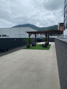 a patio on the roof of a building with a picnic shelter at Flat 205 Homebusiness perto do centro! in Pomerode