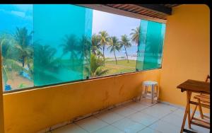 a room with a large window with a view of the ocean at Pousada Pé na Areia in São José da Coroa Grande
