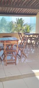 a group of picnic tables and chairs on a patio at Pousada Pé na Areia in São José da Coroa Grande