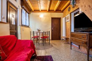 een woonkamer met een tv en een tafel met stoelen bij Beb chalet bella vita Trento in Vignola