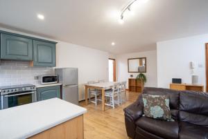 een keuken en een woonkamer met een bank en een tafel bij Belfast 2 Bed Apartment in Belfast