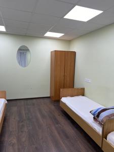 a room with two beds and a cabinet at Hostel Krone GOK Zatishok in Kyiv