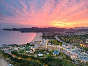 an aerial view of a resort and the beach at sunset at Hilton Dalian Golden Pebble Beach Resort in Jinzhou